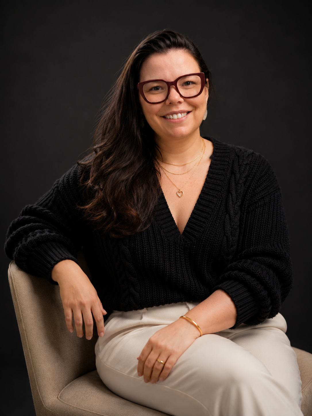 Rebecca Sanches Marcellino, advogada, sentada em uma poltrona, sorrindo